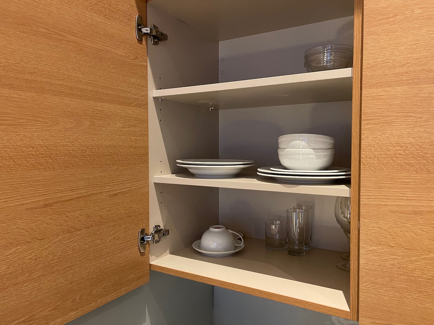 a cabinet with shelves and plates and glasses