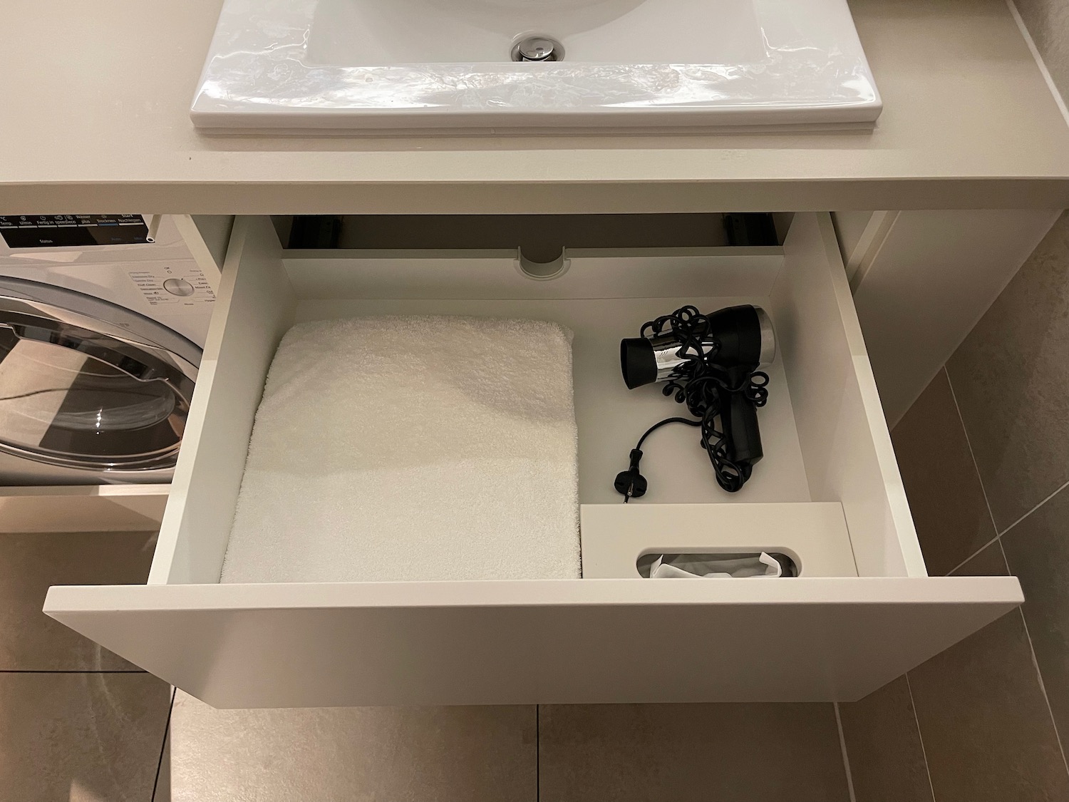 a bathroom sink with a towel and a hair dryer