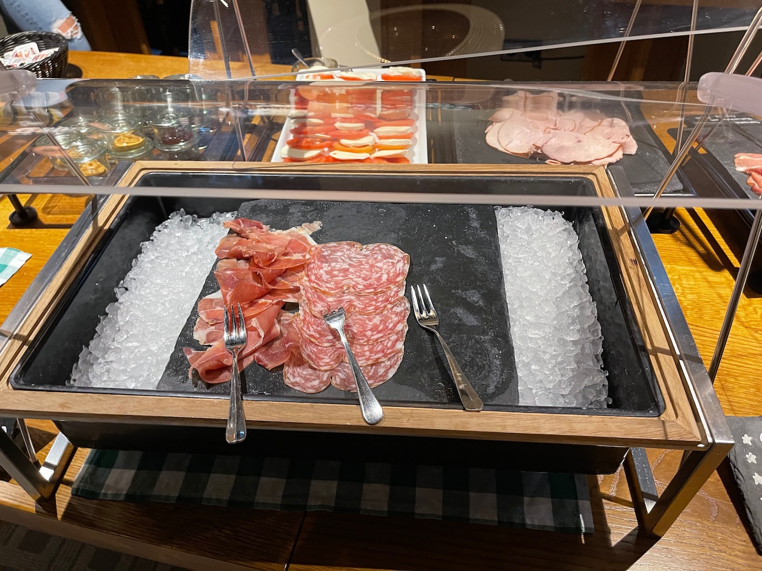 a tray of meat and ice with forks