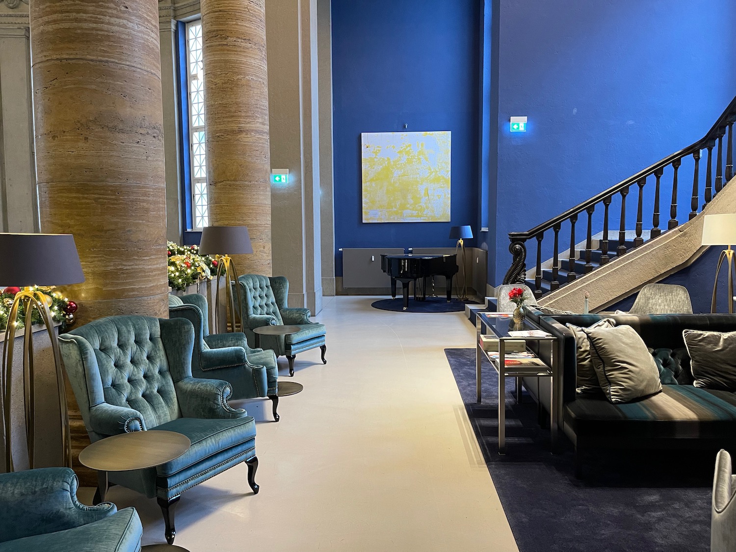 a room with blue walls and a piano and chairs