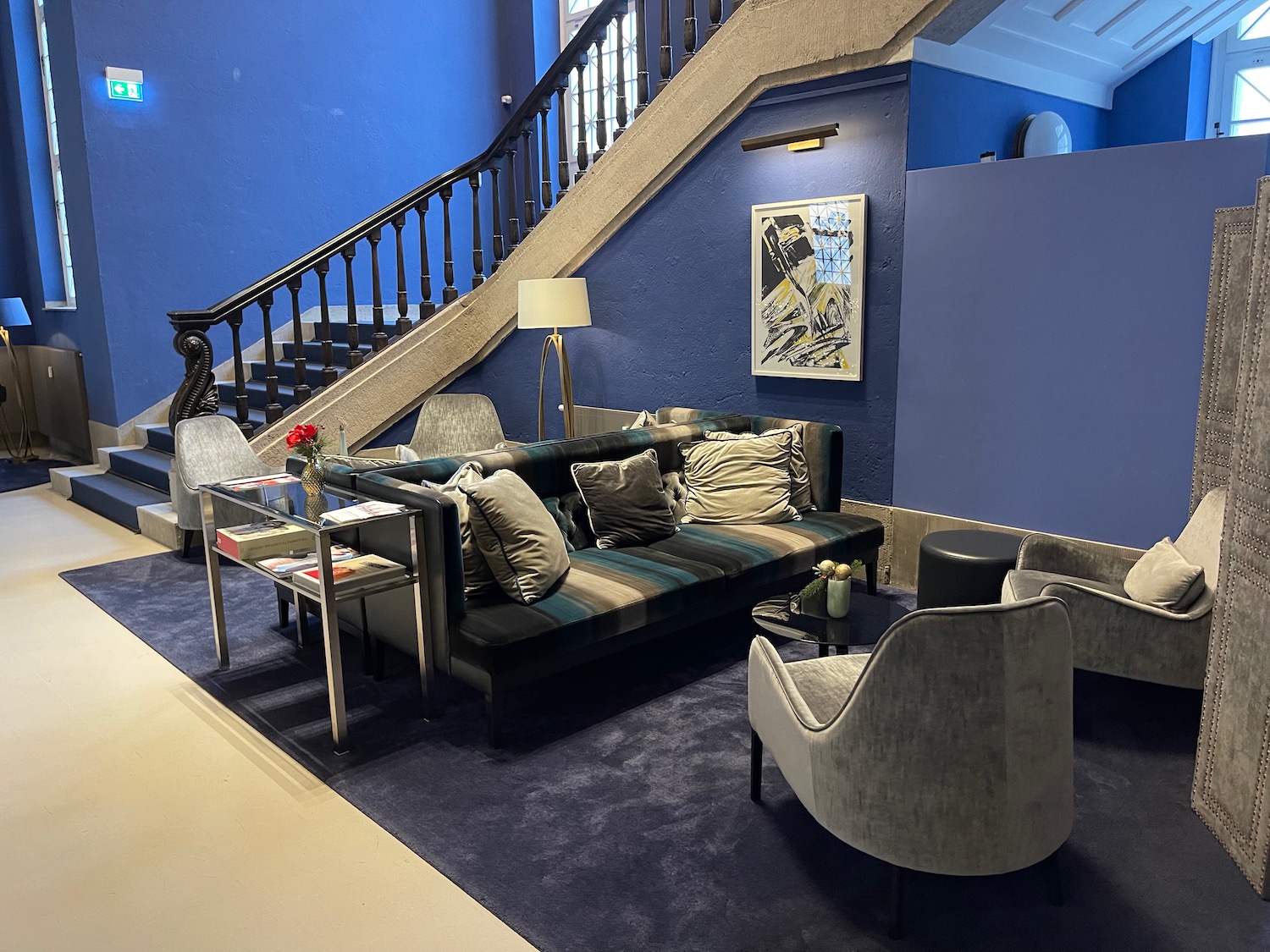 a blue and white living room with a staircase and couches