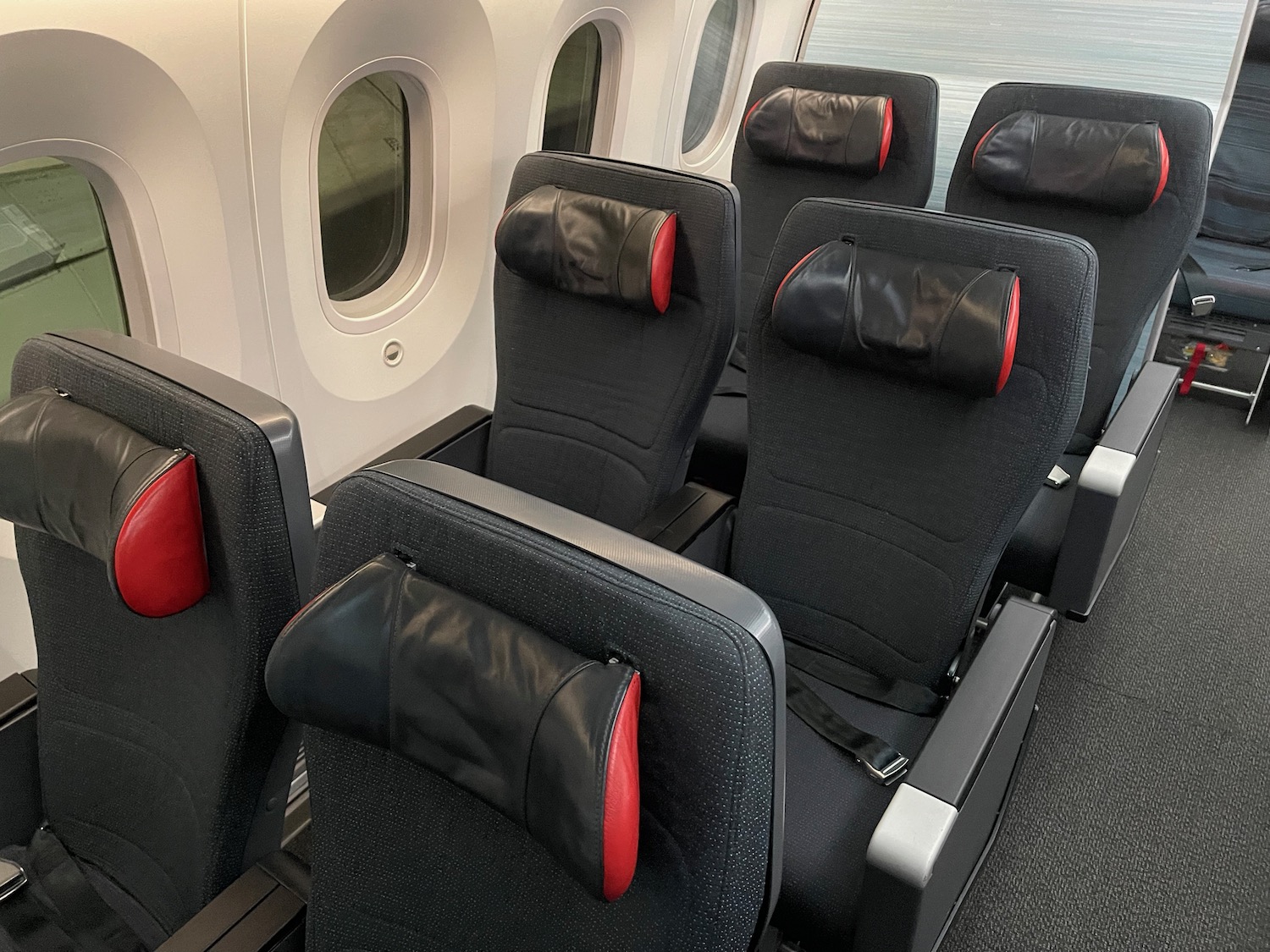 a row of black and red seats in a plane