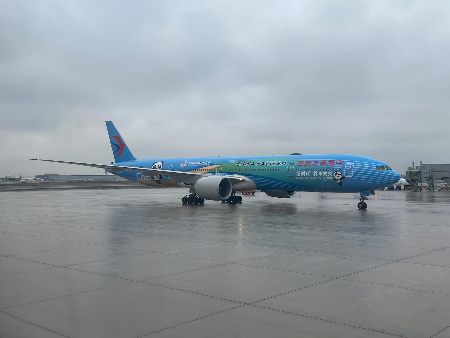 a blue and green airplane on a runway