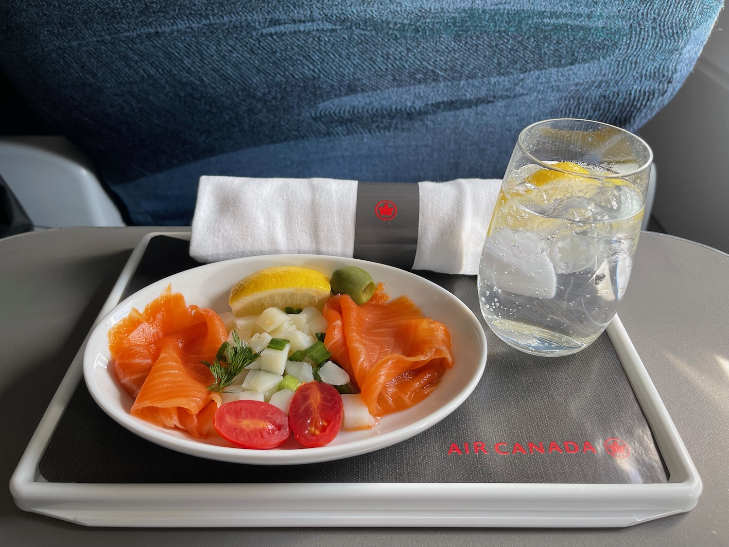 a plate of food and a glass of water on a tray