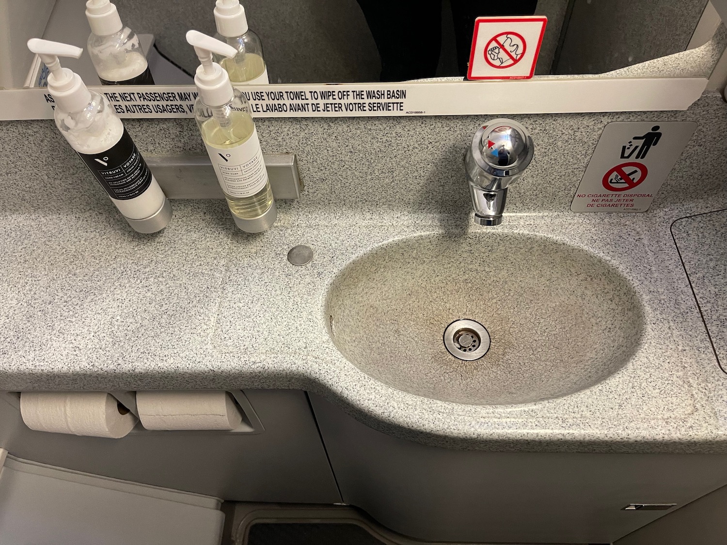 a sink with soap dispensers and a sign