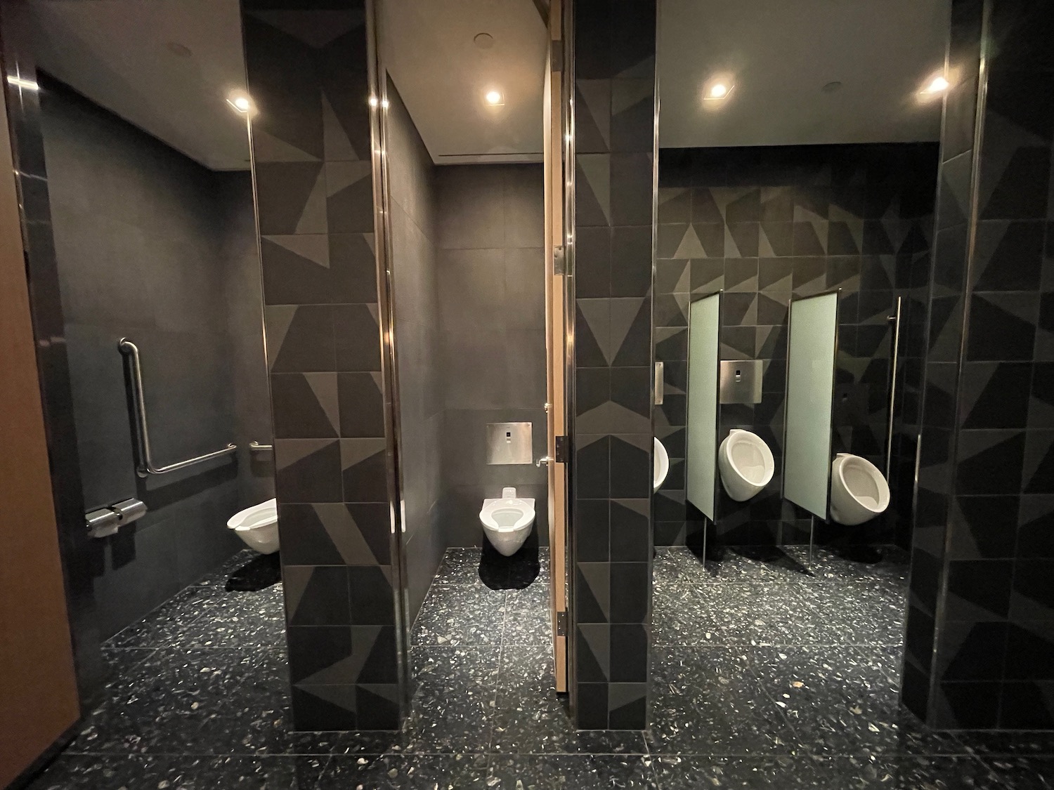 a bathroom with urinals and mirrors