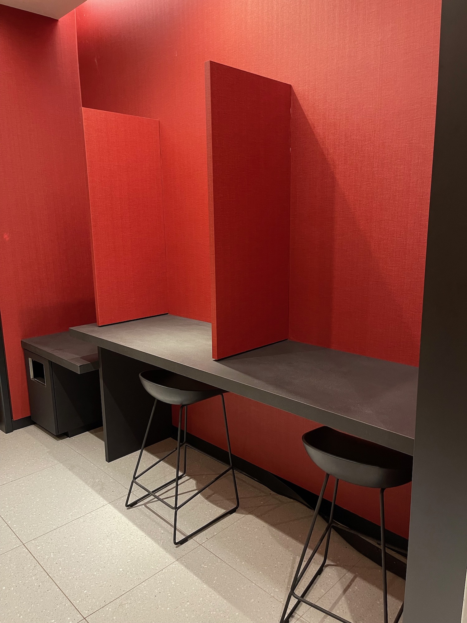 a red wall with a counter and stools