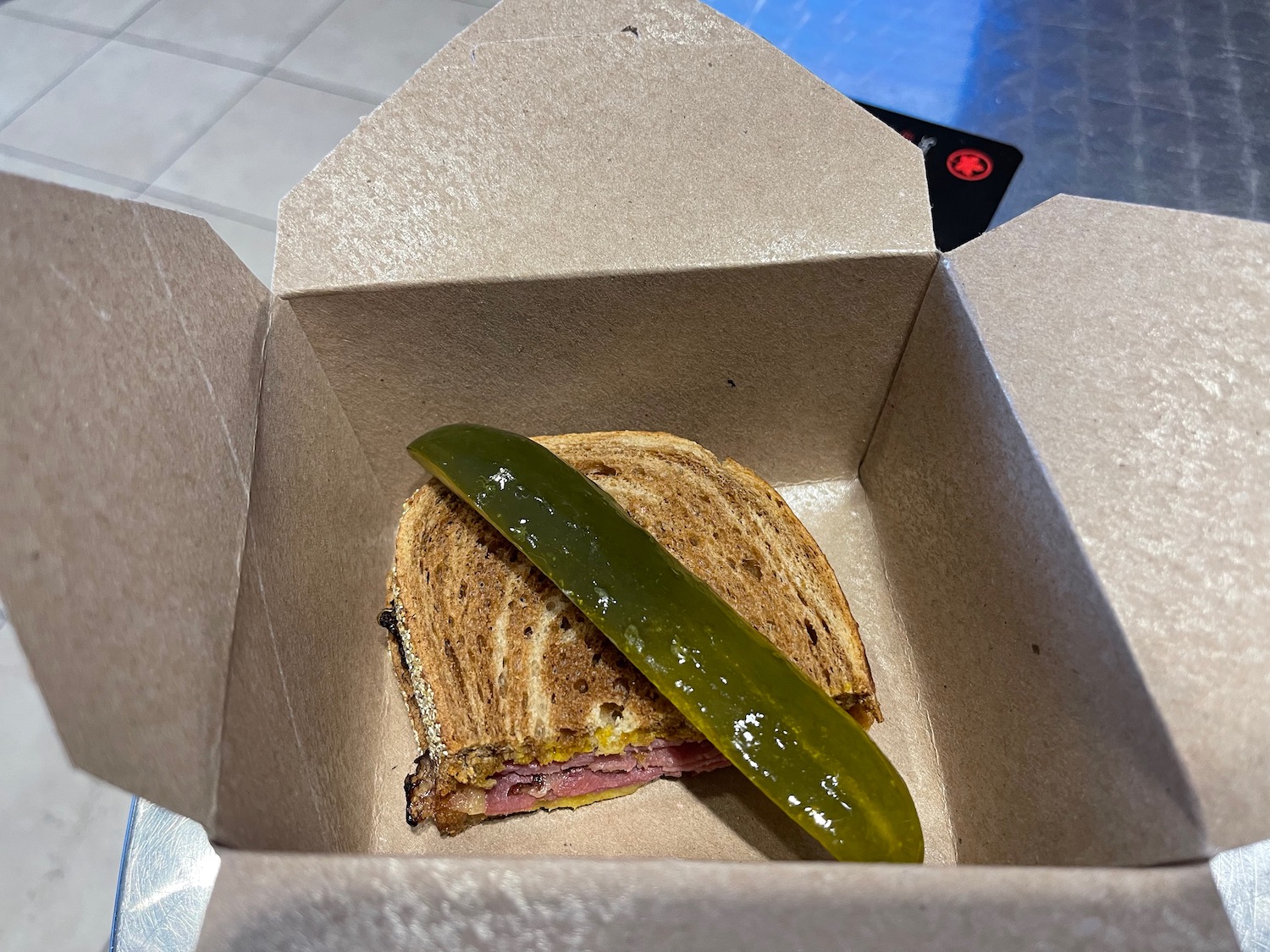 a sandwich and pickle in a box