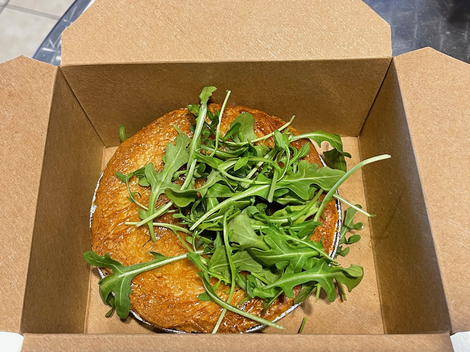 a pie with greens in a box