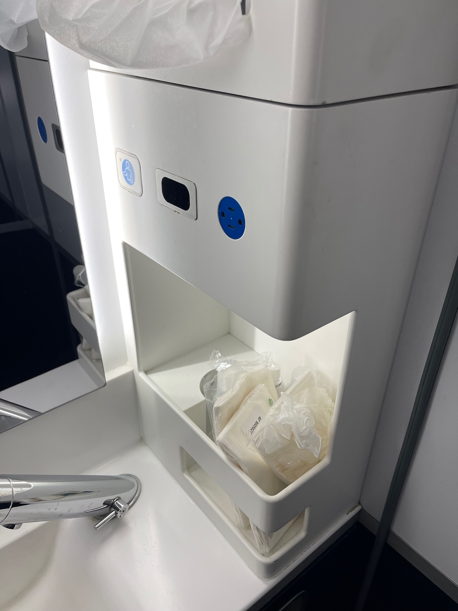 a white sink with a shelf and blue buttons