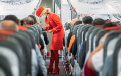 a woman wearing a mask and standing in a row of seats