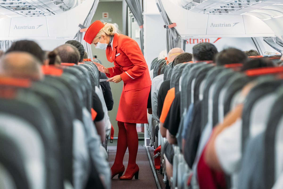 a woman wearing a mask and standing in a row of seats