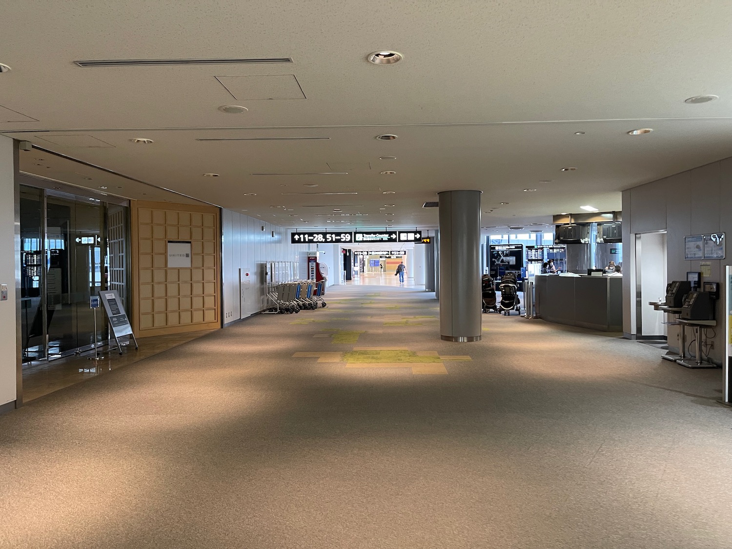 a large hallway with a sign and luggage cart