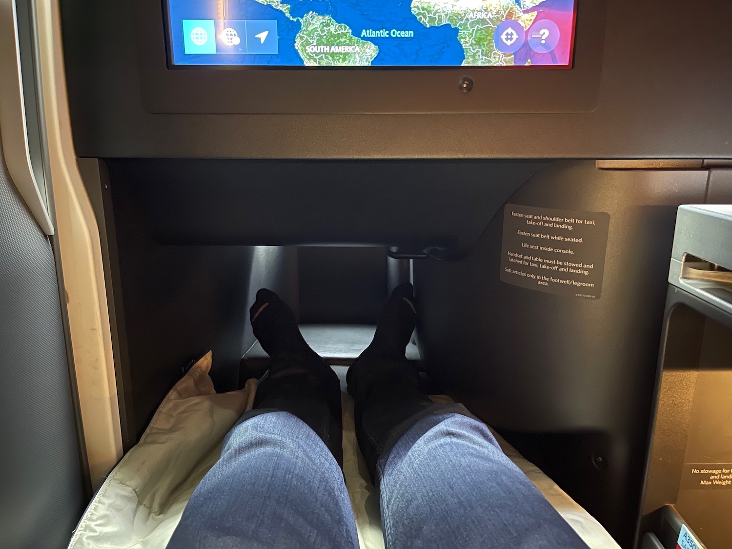 a person's legs in a seat with a screen