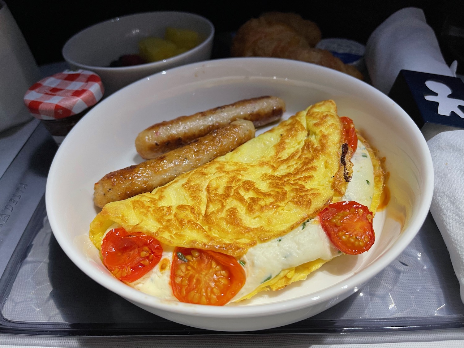 a bowl of food with sausages and omelette