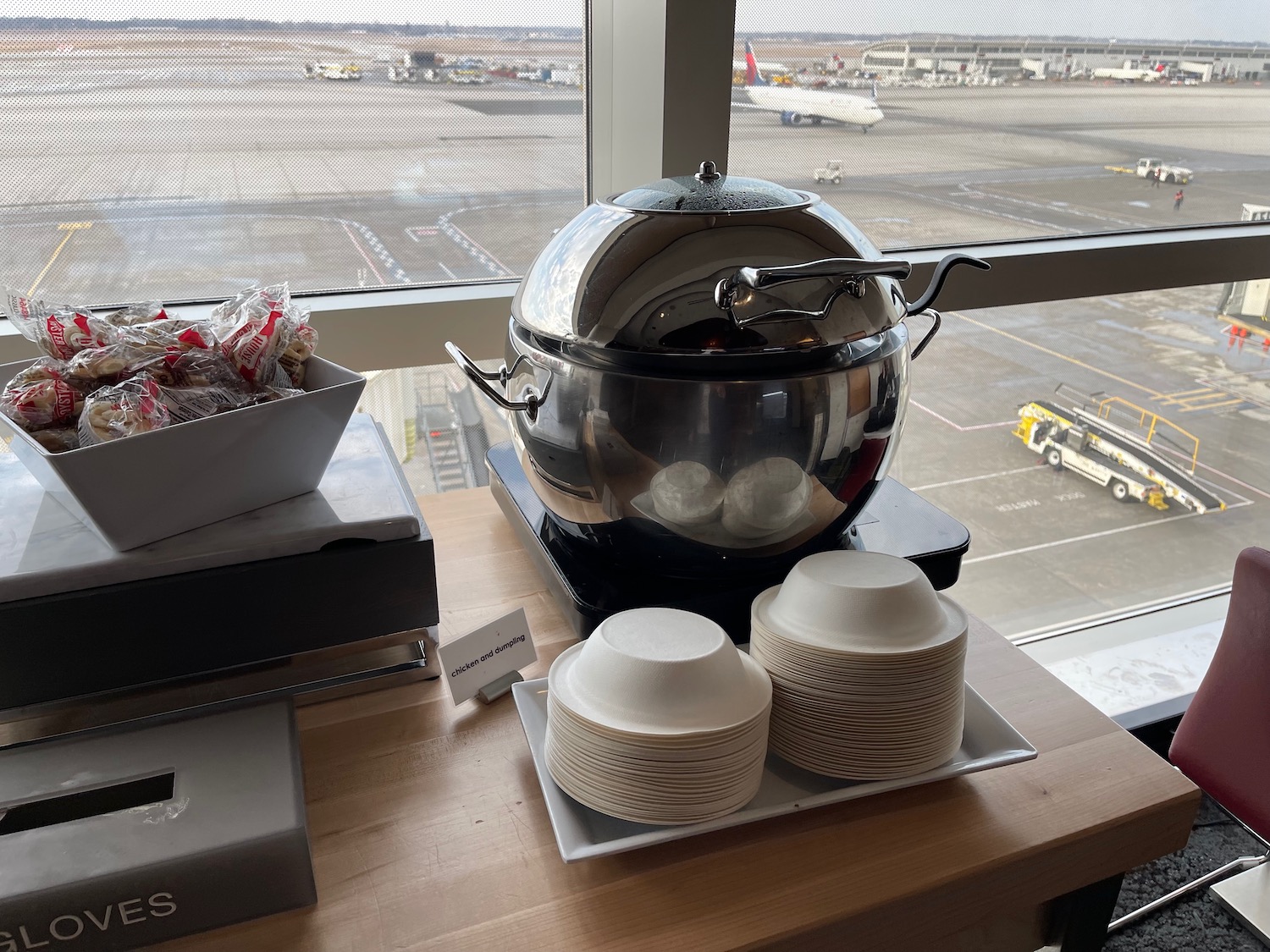 a large silver pot on a table with plates and bowls