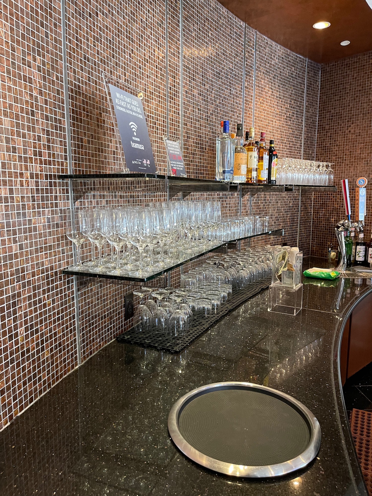 a bar with many glasses and bottles on shelves