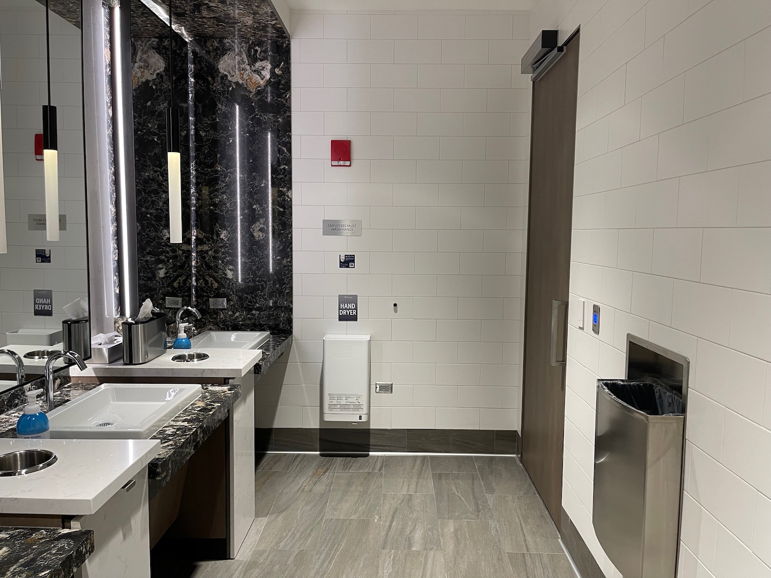 a bathroom with marble tile walls and sinks