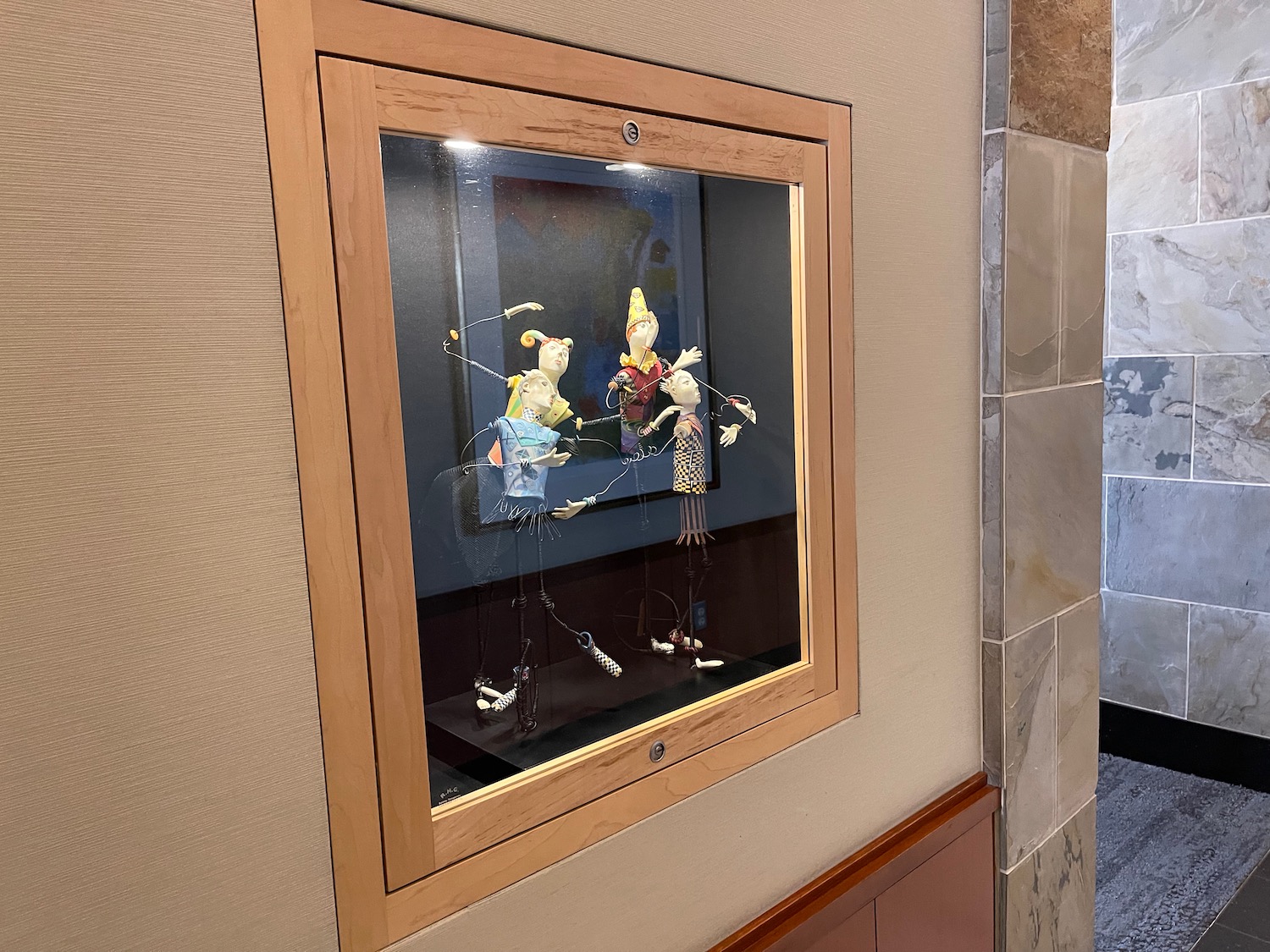 a wooden framed display case with puppets