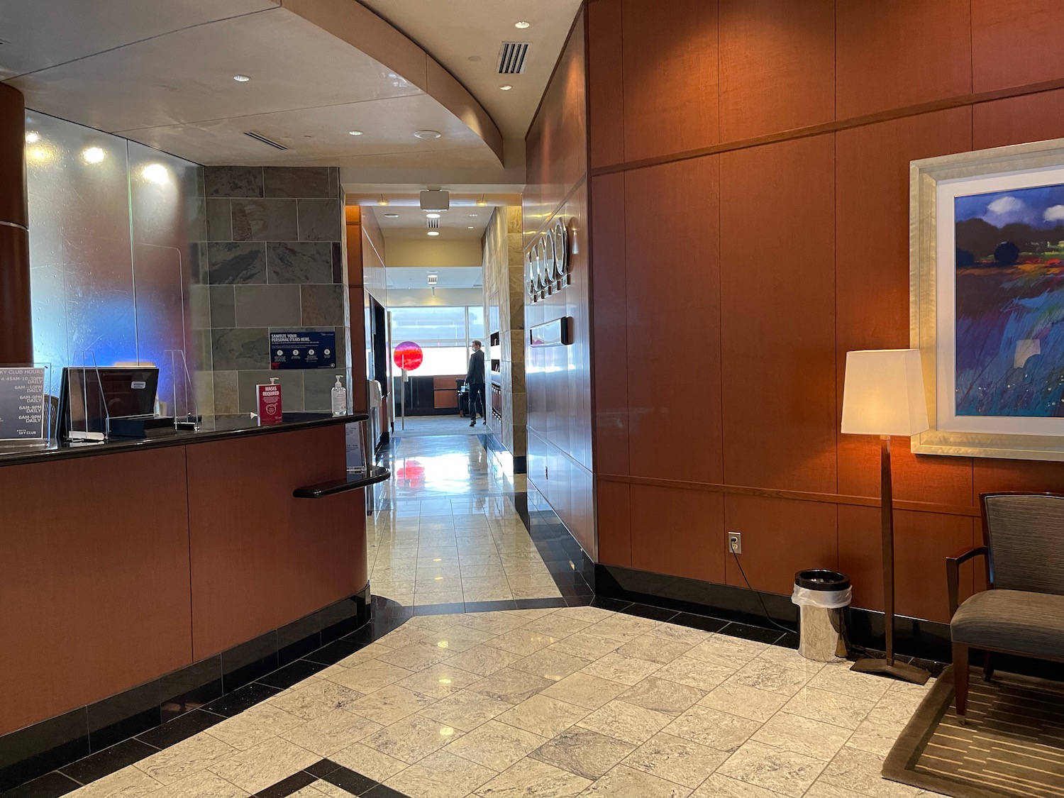 a hallway with a reception desk and a lamp