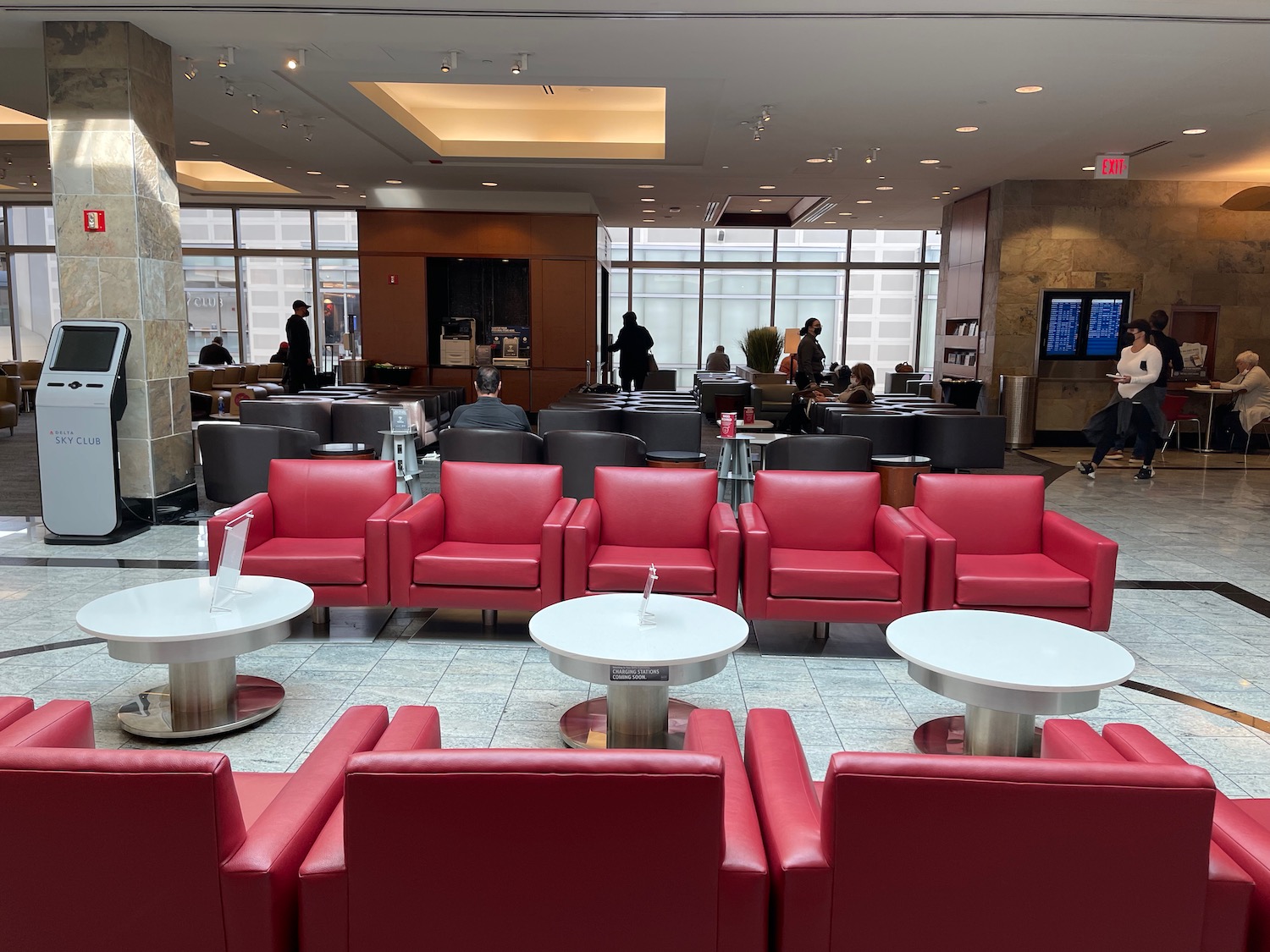 a group of people in a room with red chairs and tables