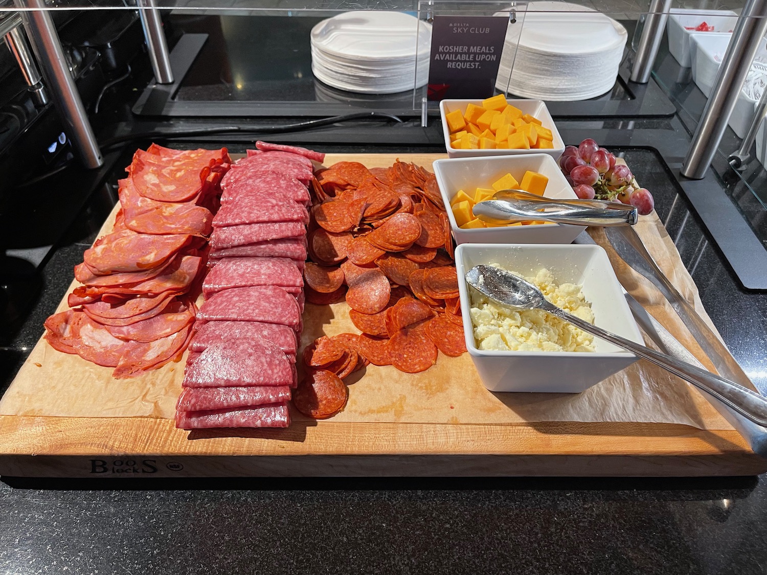 a cutting board with different types of meats and cheese