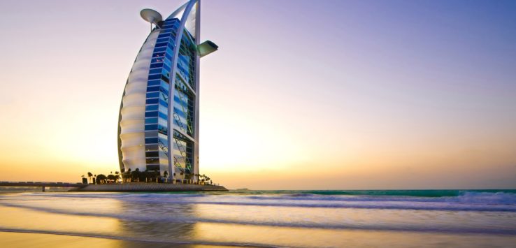 a tall building on a beach with Burj Al Arab in the background