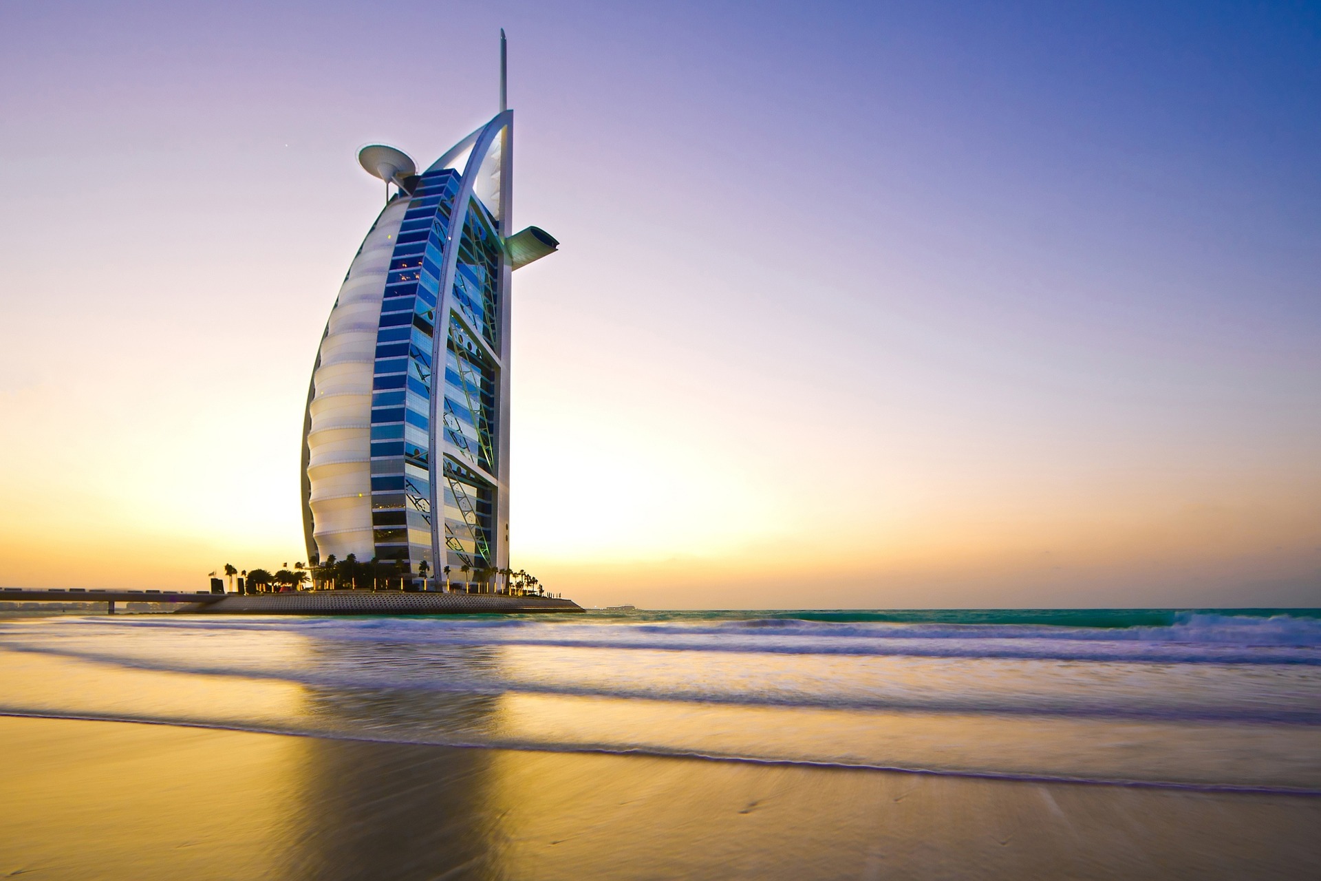 a tall building on a beach with Burj Al Arab in the background