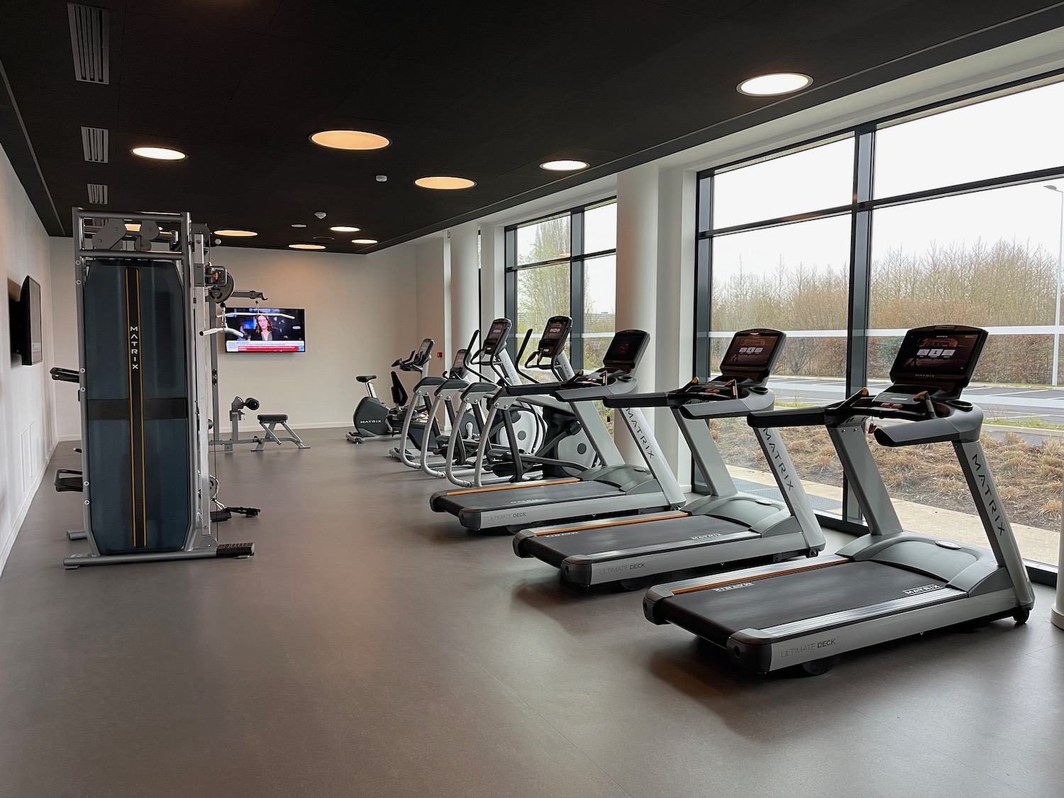 a room with exercise machines and a large window