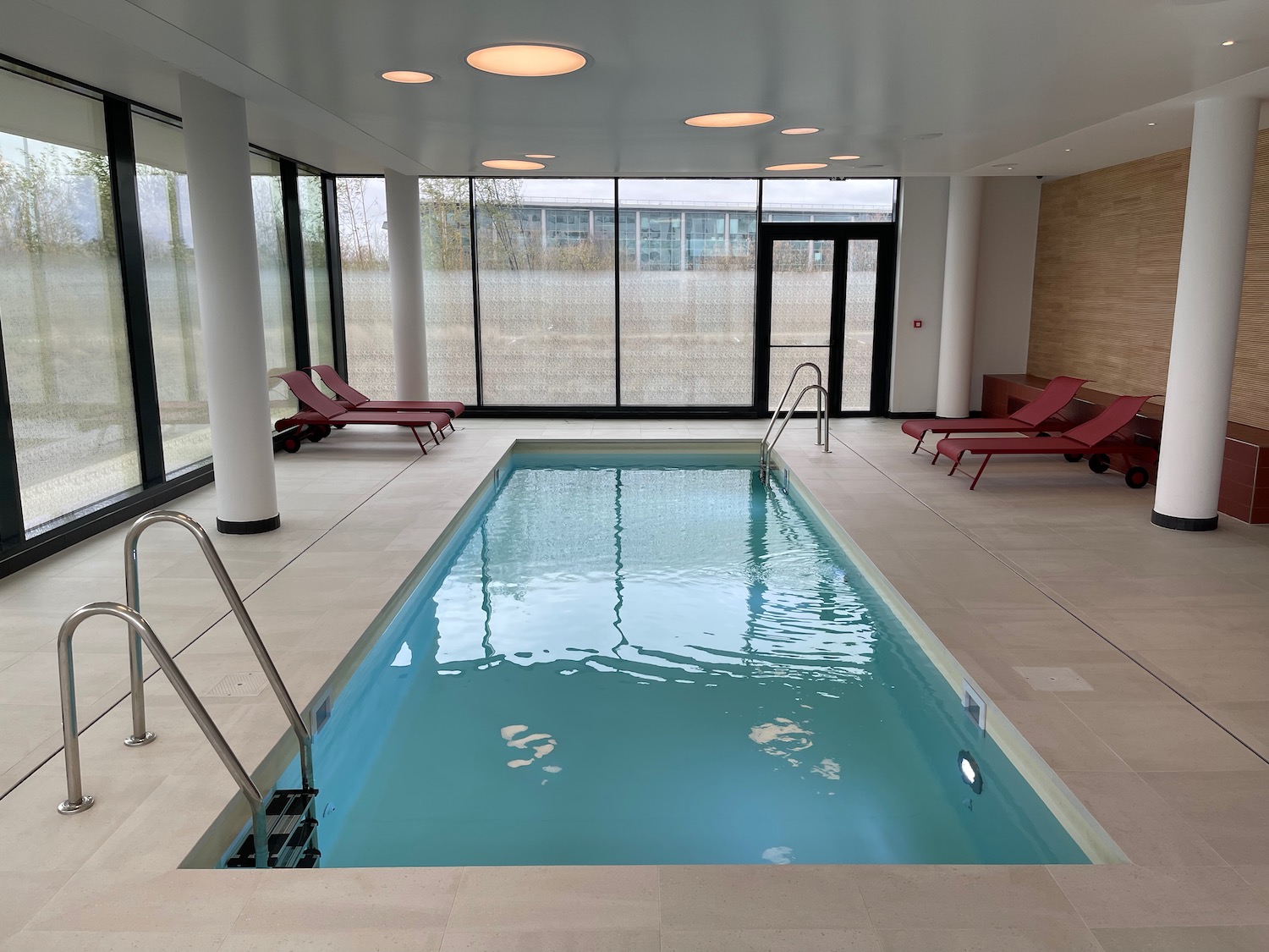 a indoor pool with chairs and a large window