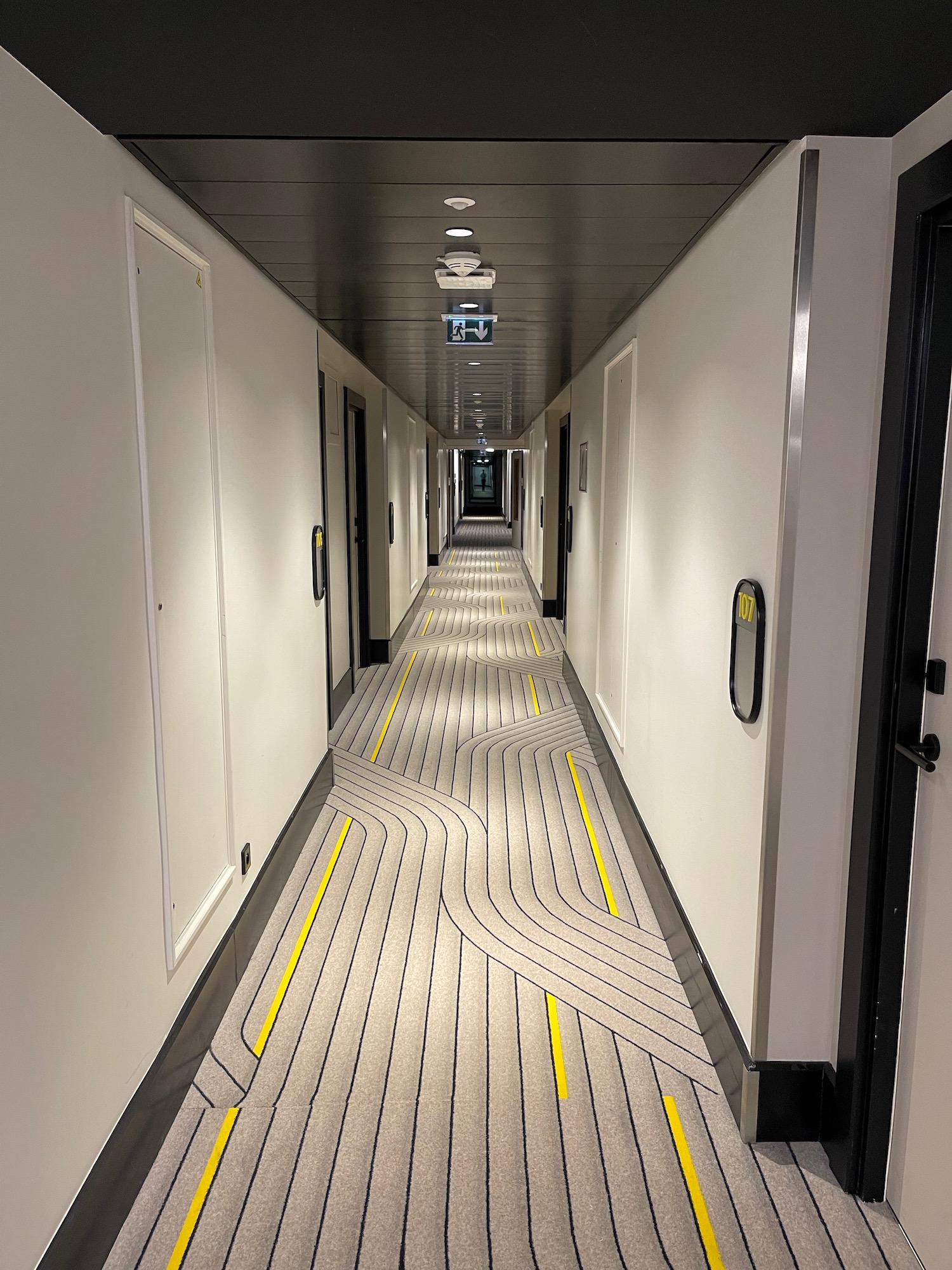 a long hallway with white walls and yellow lines