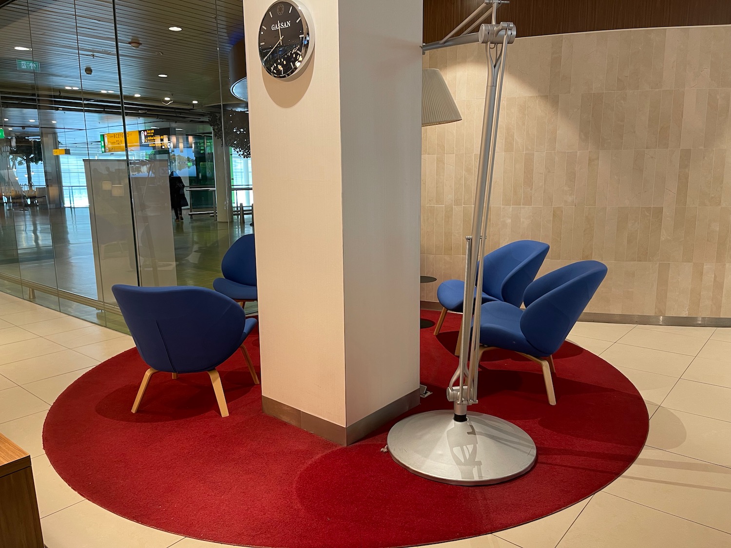 a column with blue chairs and a clock