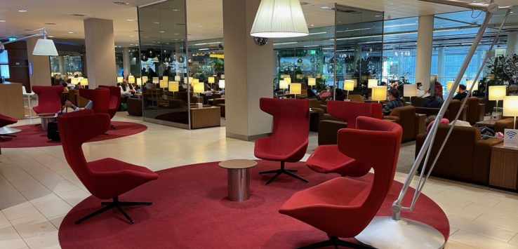 a room with red chairs and a lamp