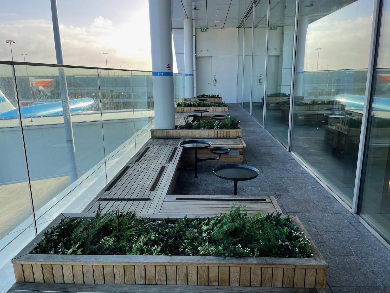 a building with glass walls and a bench with plants