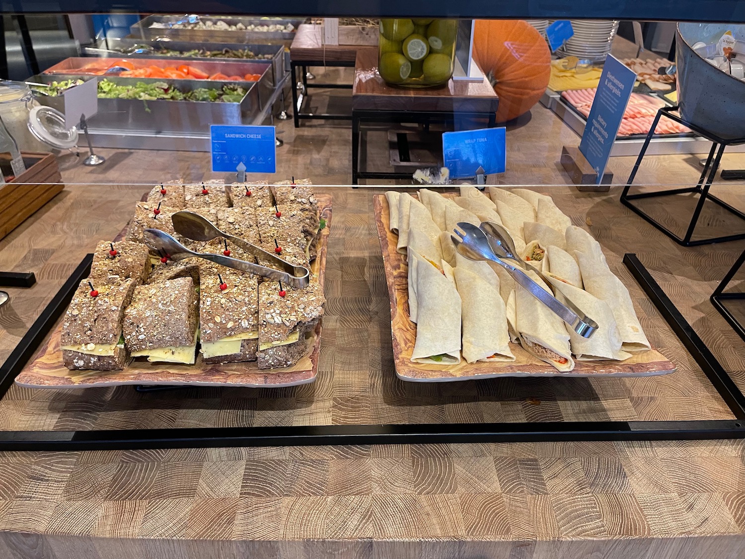a plate of sandwiches and burritos on a glass case