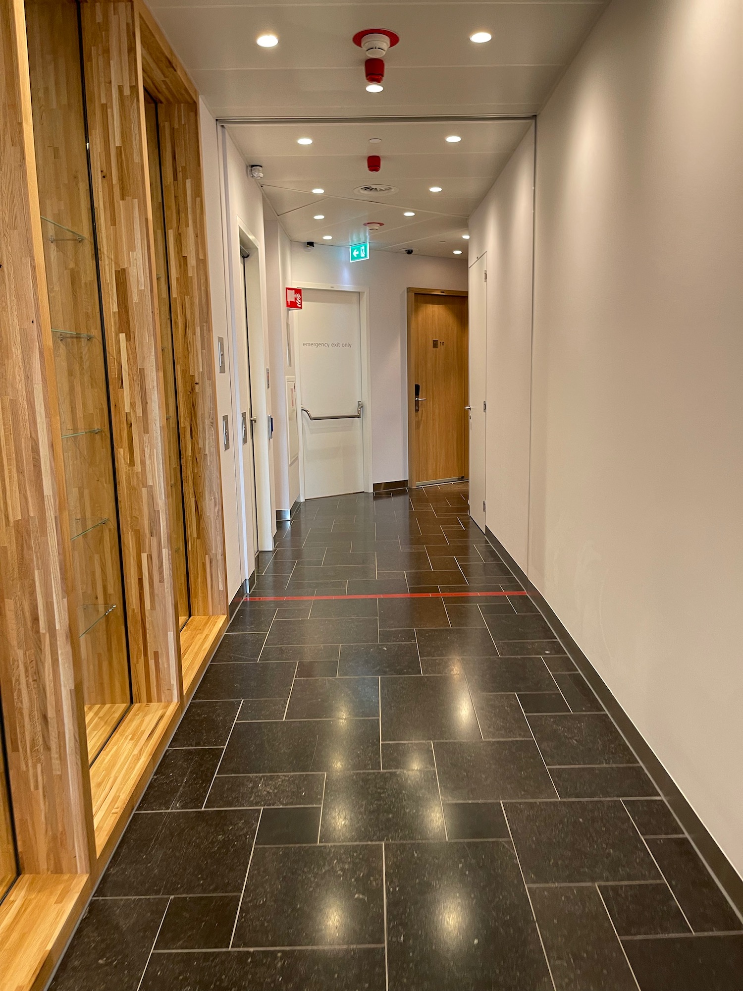 a hallway with doors and a black tile floor