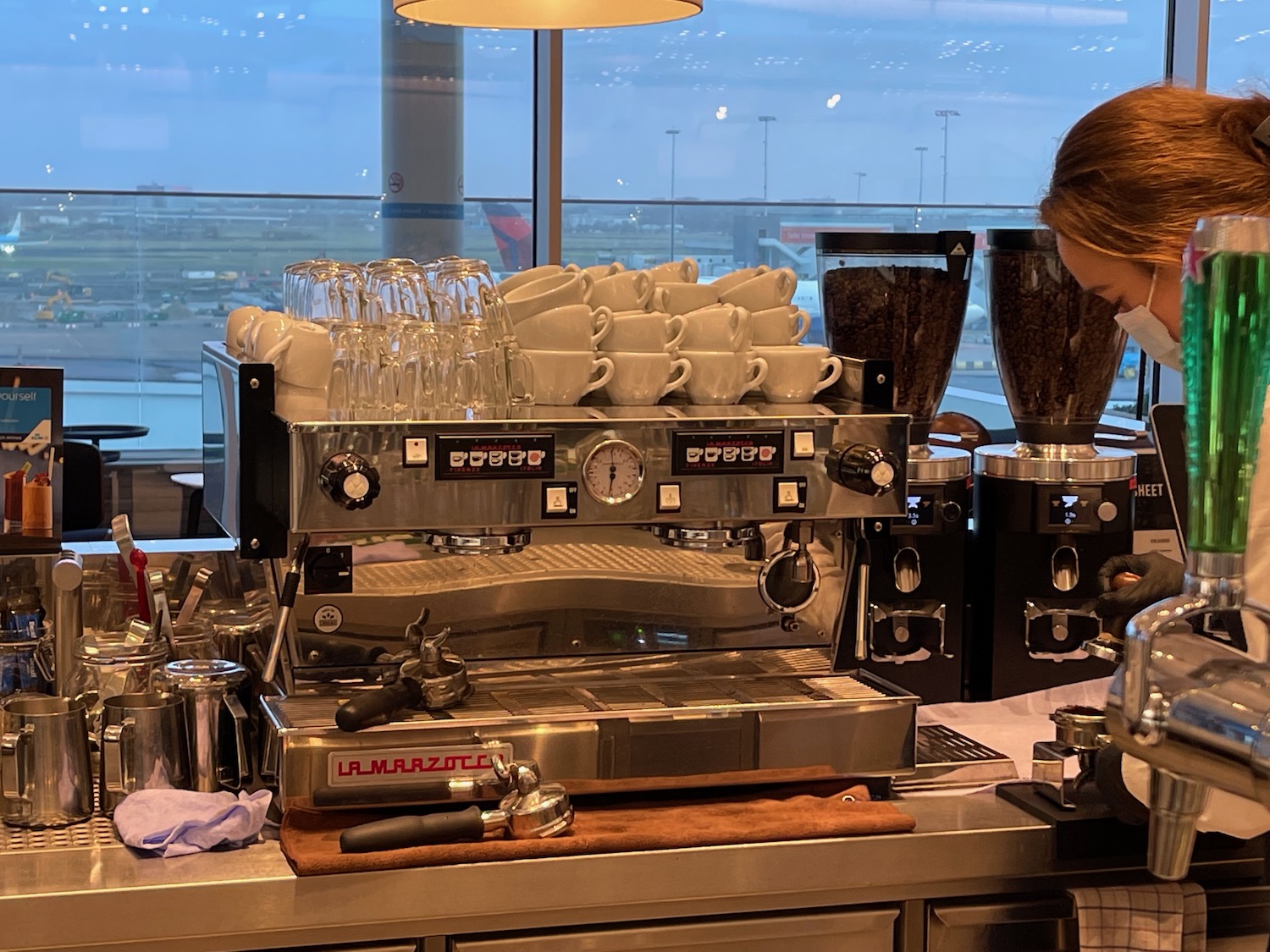 a woman standing behind a coffee machine