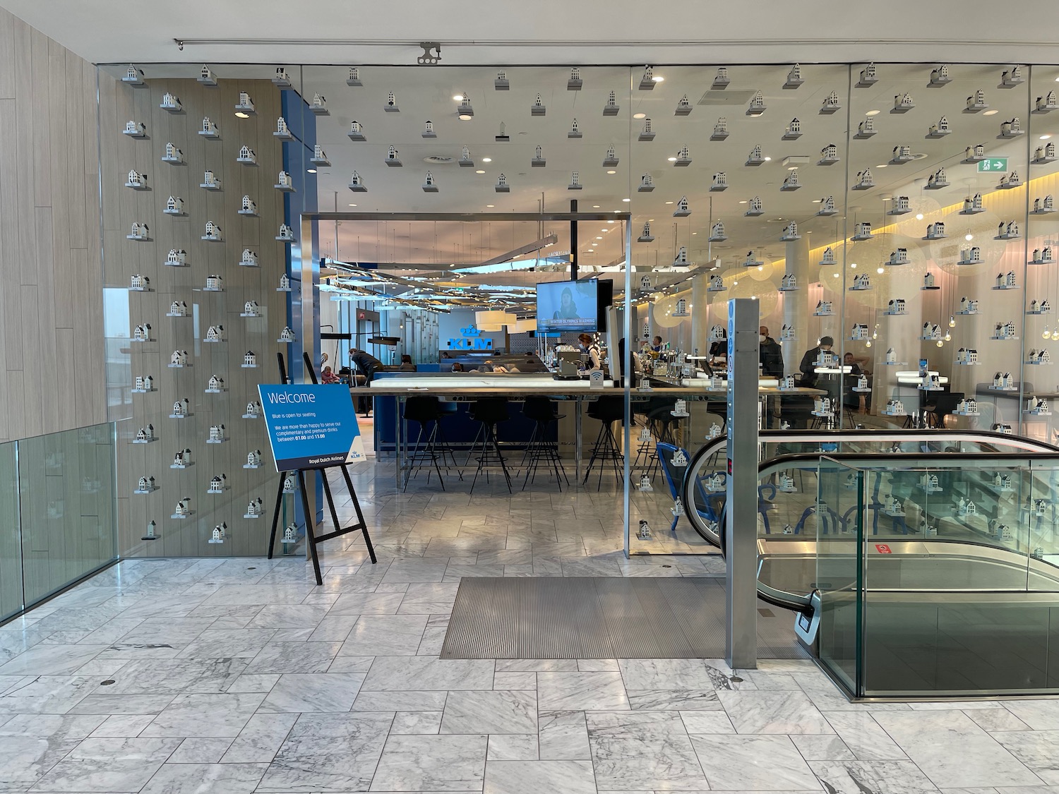 a glass wall with a sign and a table with chairs and a blue sign