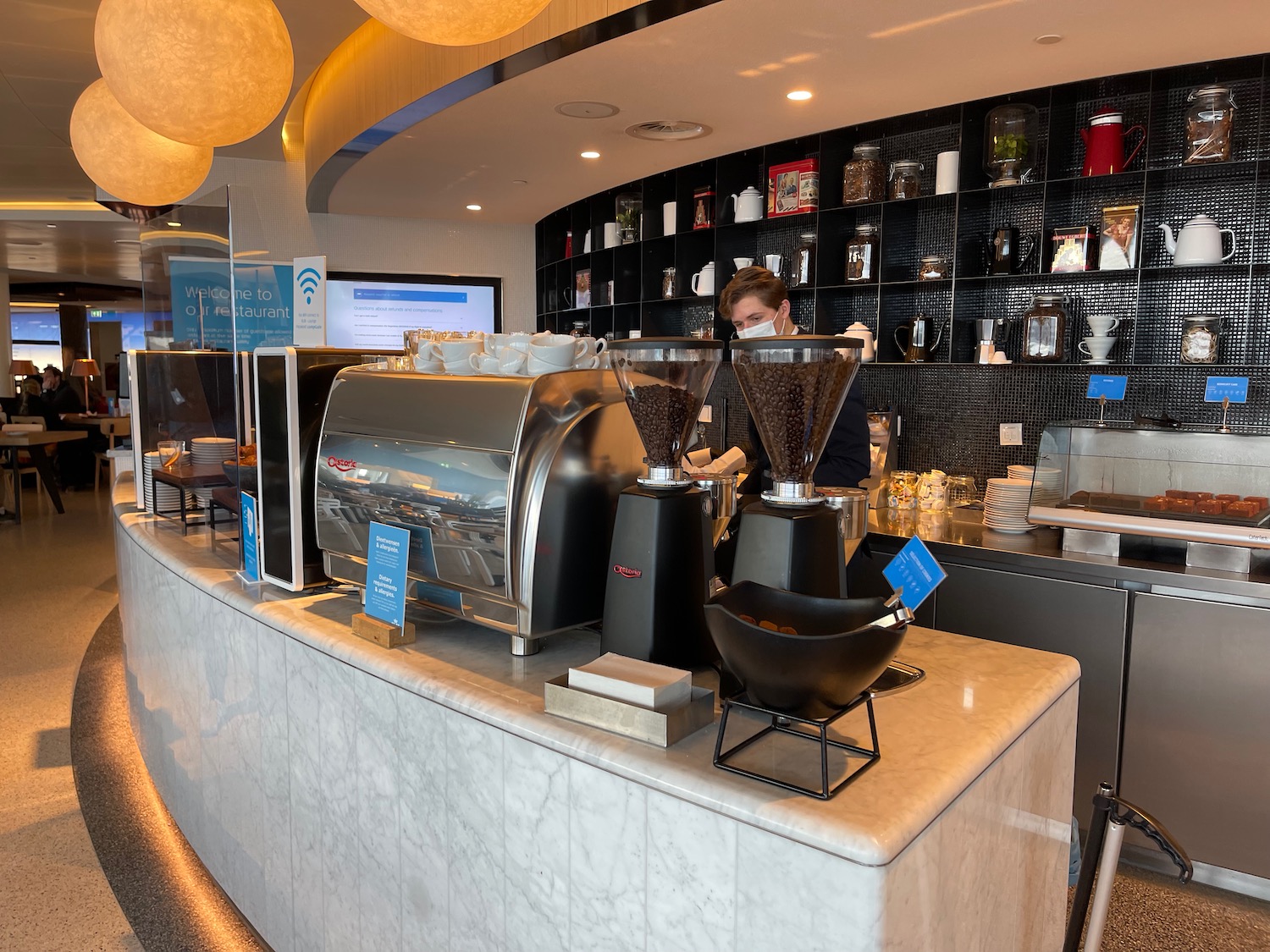 a person behind a counter with coffee grinders