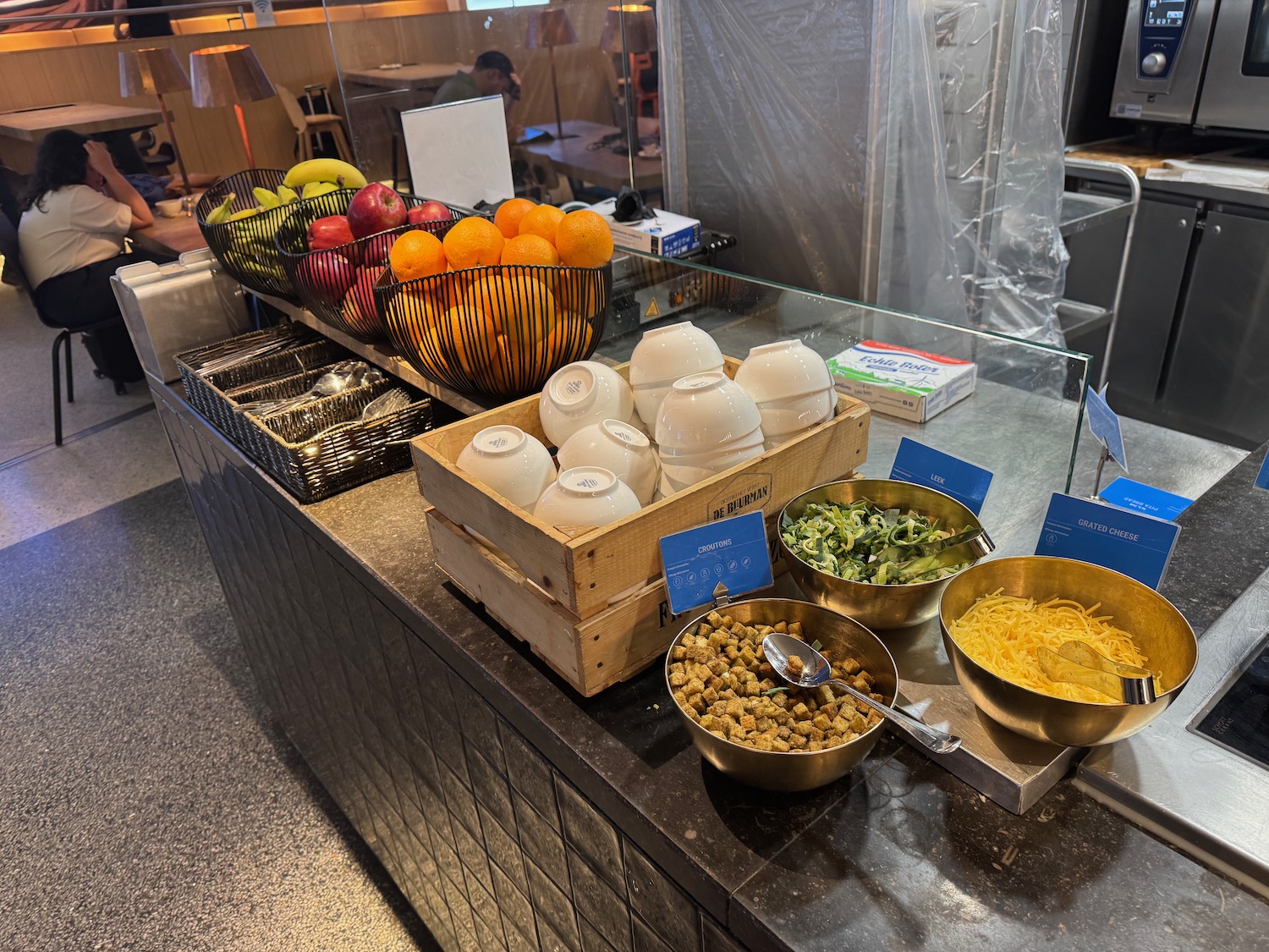 a counter with bowls of food and fruits