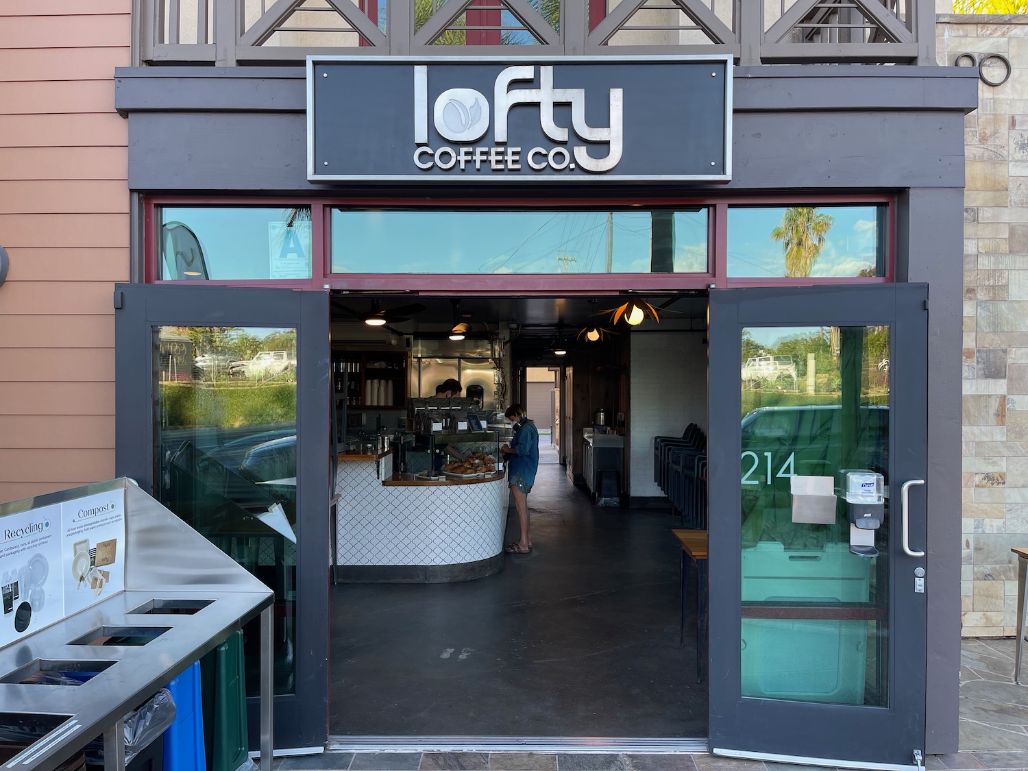 a store front with a sign and a woman standing in front of it