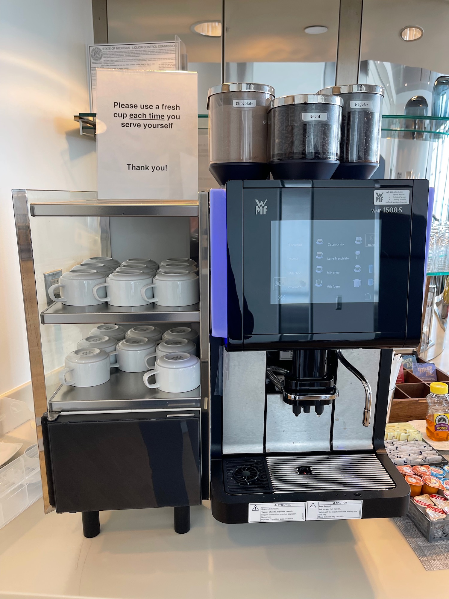 a coffee machine with a shelf full of coffee cups