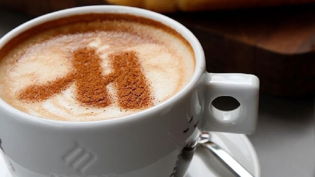 a cup of coffee with a letter on the foam