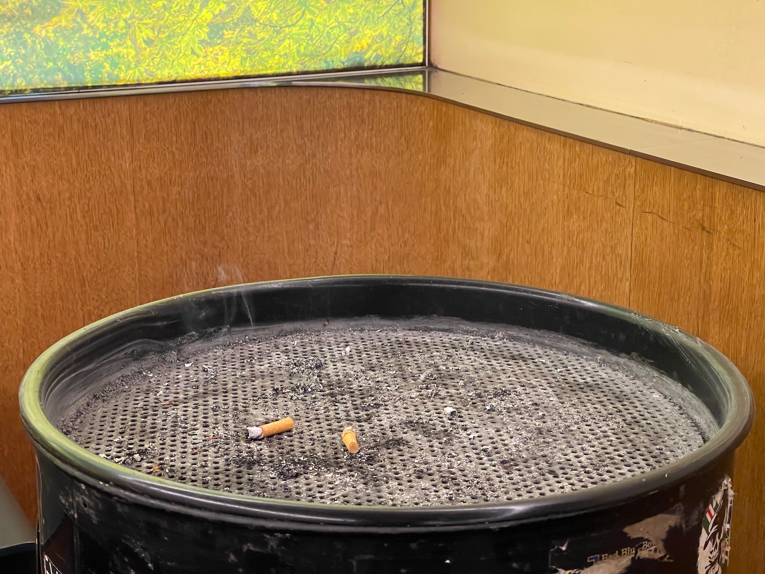a cigarette butts on a black round ashtray