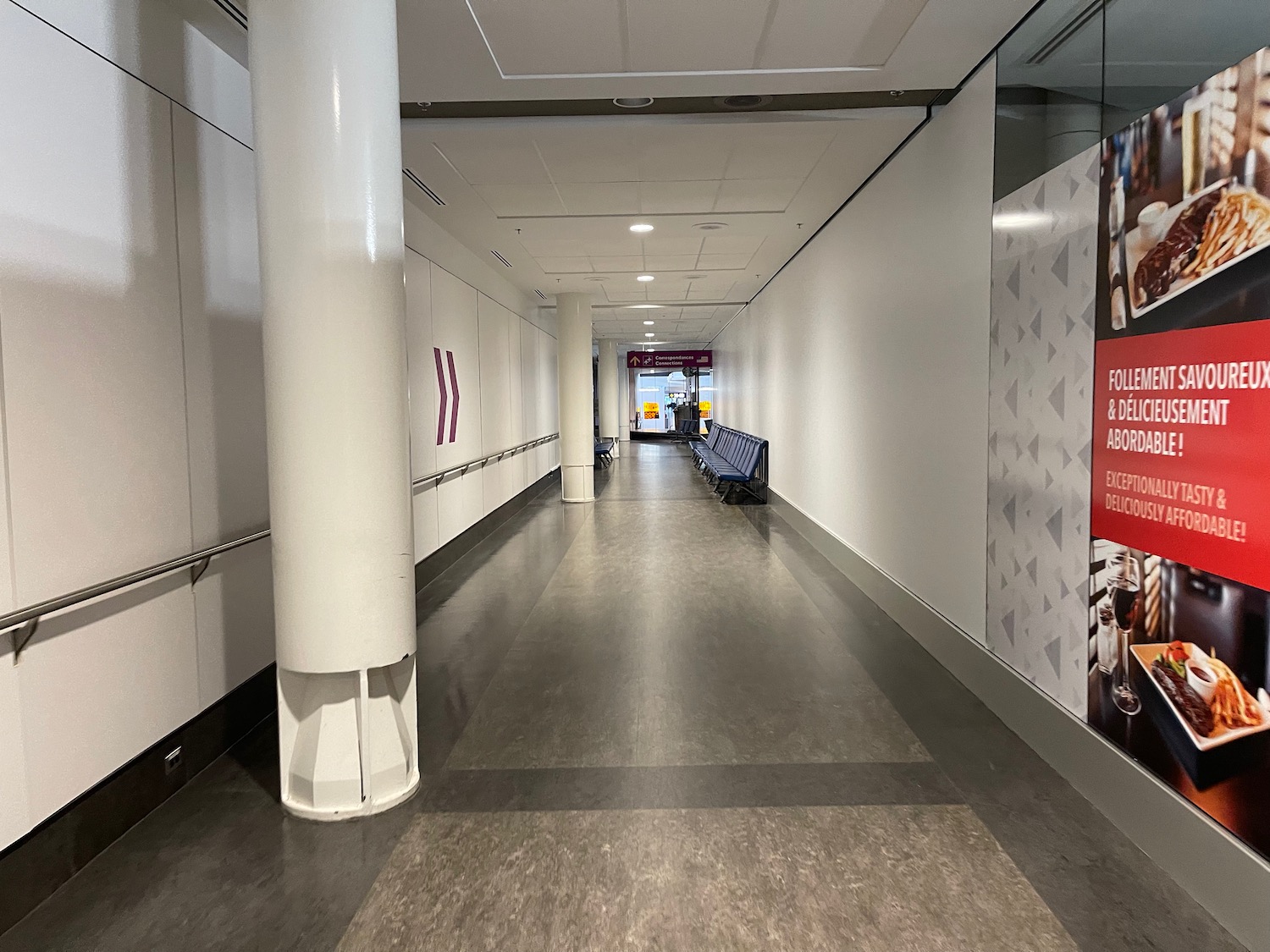 a long hallway with benches and signs