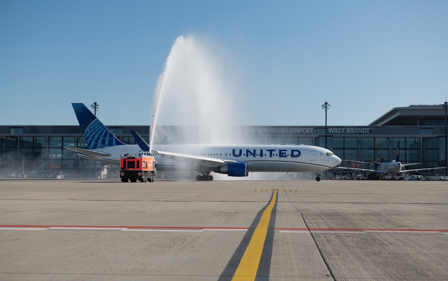 a jet plane spraying water on runway