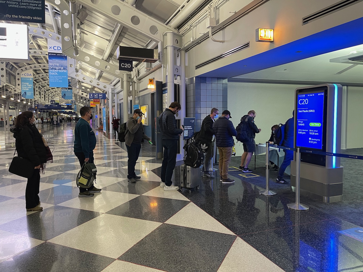 a group of people standing in a line in a terminal