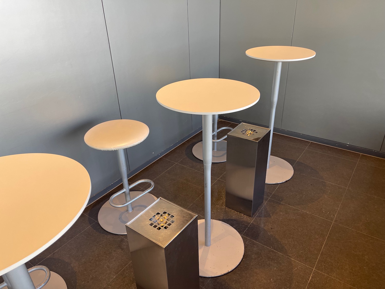 a group of tables and trash can in a room