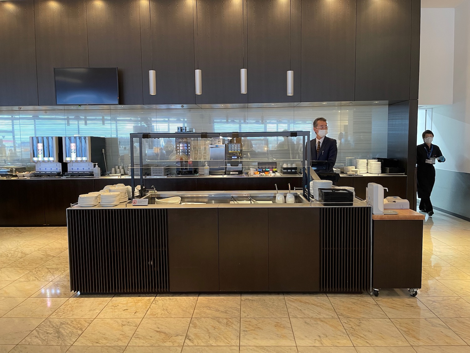 a man in a mask behind a counter in a restaurant