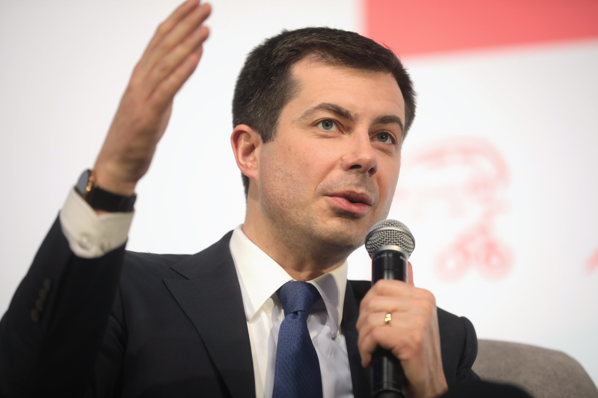 a man in a suit and tie holding a microphone